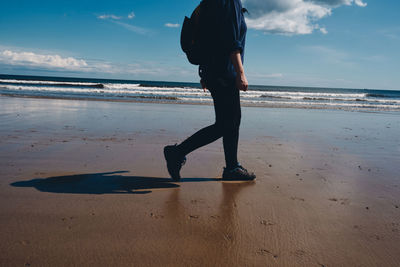 Full length of man standing on beach against sky