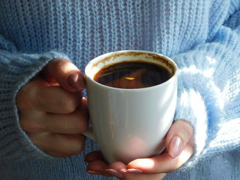 Close-up of hand holding coffee cup