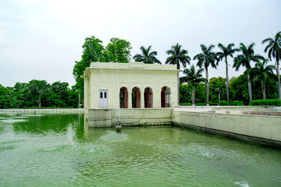 View of swimming pool by lake against sky