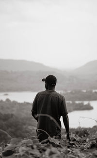 Rear view of man looking at sea against sky