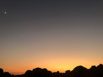 Low angle view of silhouette mountains against clear sky at sunset