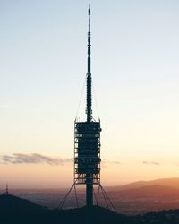 Silhouette of communications tower against clear sky