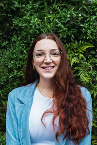 Portrait of attractive woman with long red hair. natural beauty woman with glasses looking at camera