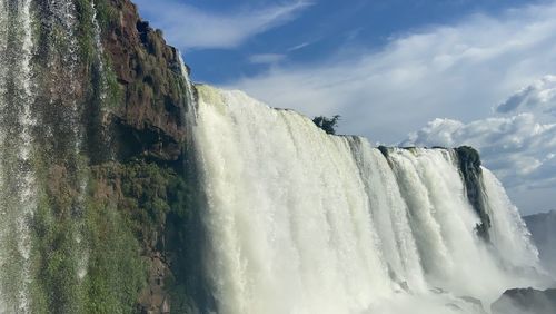 Low angle view of waterfall against sky