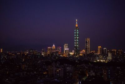 Illuminated buildings in taipei against sky at night
