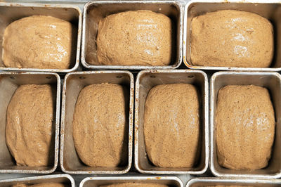 Uncooked bread in the form of dough is placed in bread tins before baking. craft bread. kravtovoe