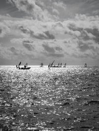 People in sea against sky