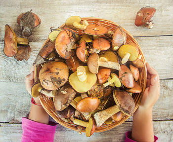 Cropped hand of woman holding food on table