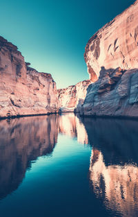 Scenic view of lake by rock formation against sky