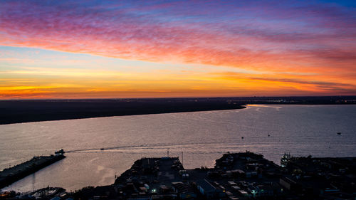 High angle view of silhouette buildings against sky during sunset