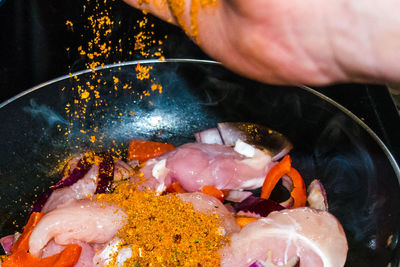 Cropped image of person seasoning meat