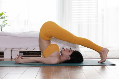 Woman with eyes closed doing yoga at home