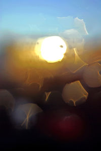 Close-up of illuminated lamp against sky during sunset