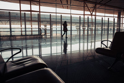 Reflection of man on glass window at airport