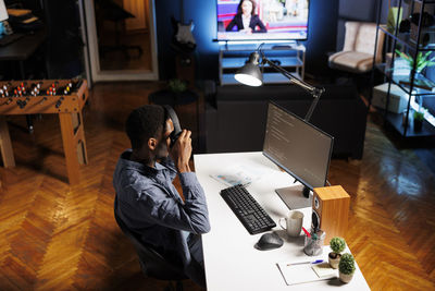 Side view of woman using laptop at table