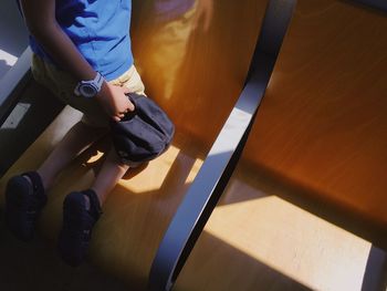 Low section of boy sitting on hardwood floor