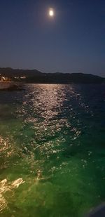 Scenic view of sea against clear sky at night