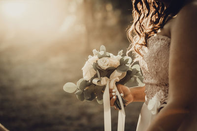 Bride with flower bouquet. summertime sunset