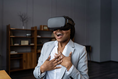 Shocked amazed black businesswoman in vr glasses enjoying first virtual reality experience at work