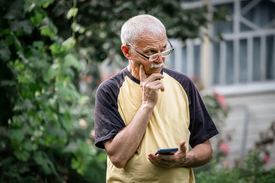 Young man using mobile phone while standing outdoors