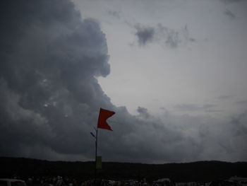 Flag on mountain road against sky