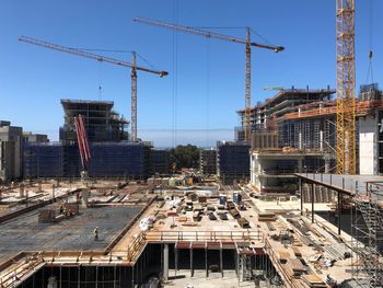 Construction site by buildings against sky in city