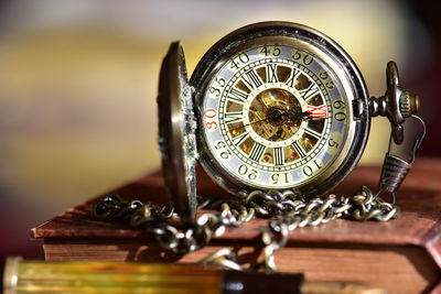 Close-up of pocket watch on book