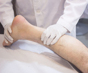 Midsection of doctor examining foot