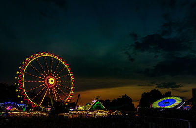 Low angle view of illuminated ferris wheel against sky at night
