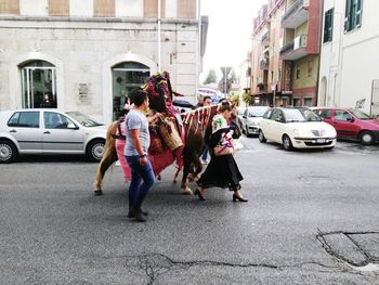 People walking with horse on street