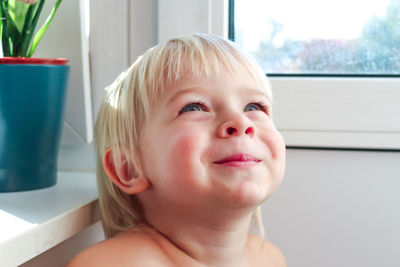 Happy child in home quarantine playing and laughing at the window. stay home concept.