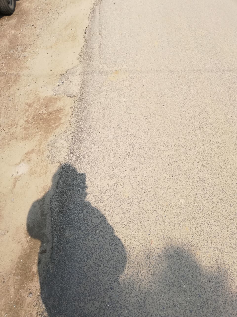 SHADOW OF PERSON ON STREET