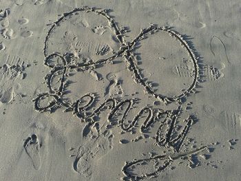 Close-up of text on sand at beach