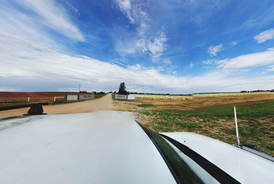 Road by landscape against sky