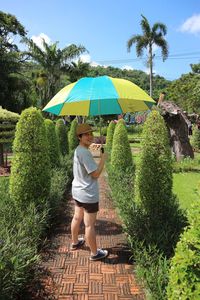 Portrait of woman with umbrella standing in garden