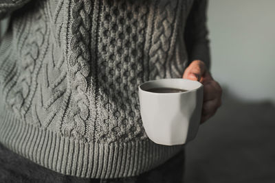 Close-up of hand holding coffee cup