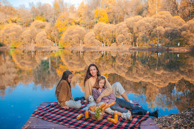 Group of people sitting in park during autumn