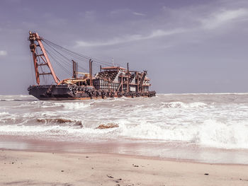 Ship on beach against sky