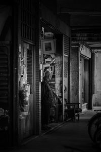 Rear view of man on street against building at night