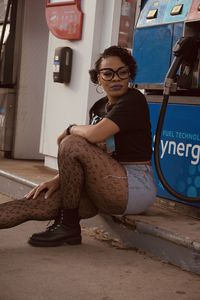 Portrait of young woman sitting at gas station