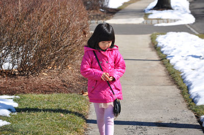 Full length of girl walking on road during winter