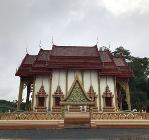 Temple by building against sky