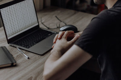 Male hands are typing on a laptop keyboard. businessman works remotely from home. online freelancing