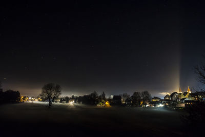 Illuminated trees against sky at night