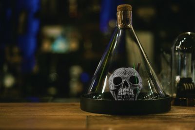 Close-up of artificial skull in glass bottle