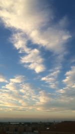 Scenic view of cityscape against cloudy sky