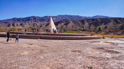 Group of people on landscape against mountain range