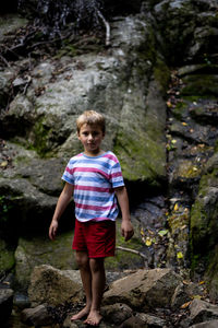 Portrait of boy standing against rocks