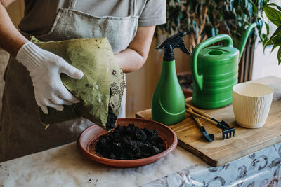 Potting soil. soil to repot indoor plants. spring houseplant care, repotting houseplants. woman is