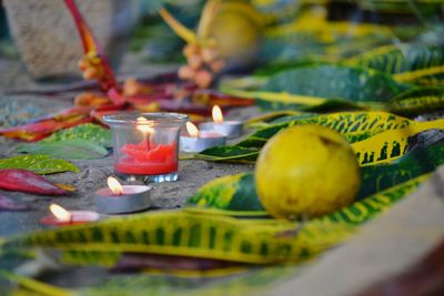 Close-up of lit candles on leaves in temple